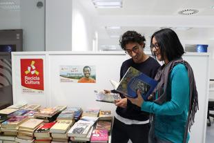 Un home i una dona consultant els llibres exposats