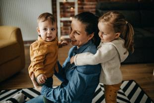 una mujer abrazando a dos niños