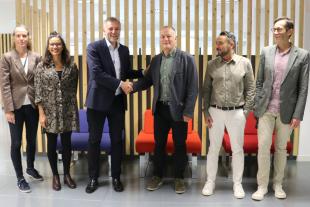El director d'i2Cat Sergi Figuerola i el codirector general de Suara Cooperativa es donen la mà per segellar l'acord