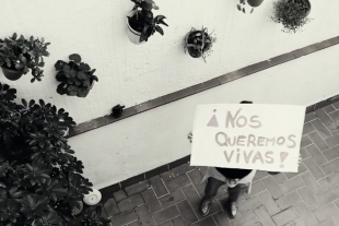 Un moment del vídeo on una de les dones aixeca un cartell amb el missatge ens volem vives