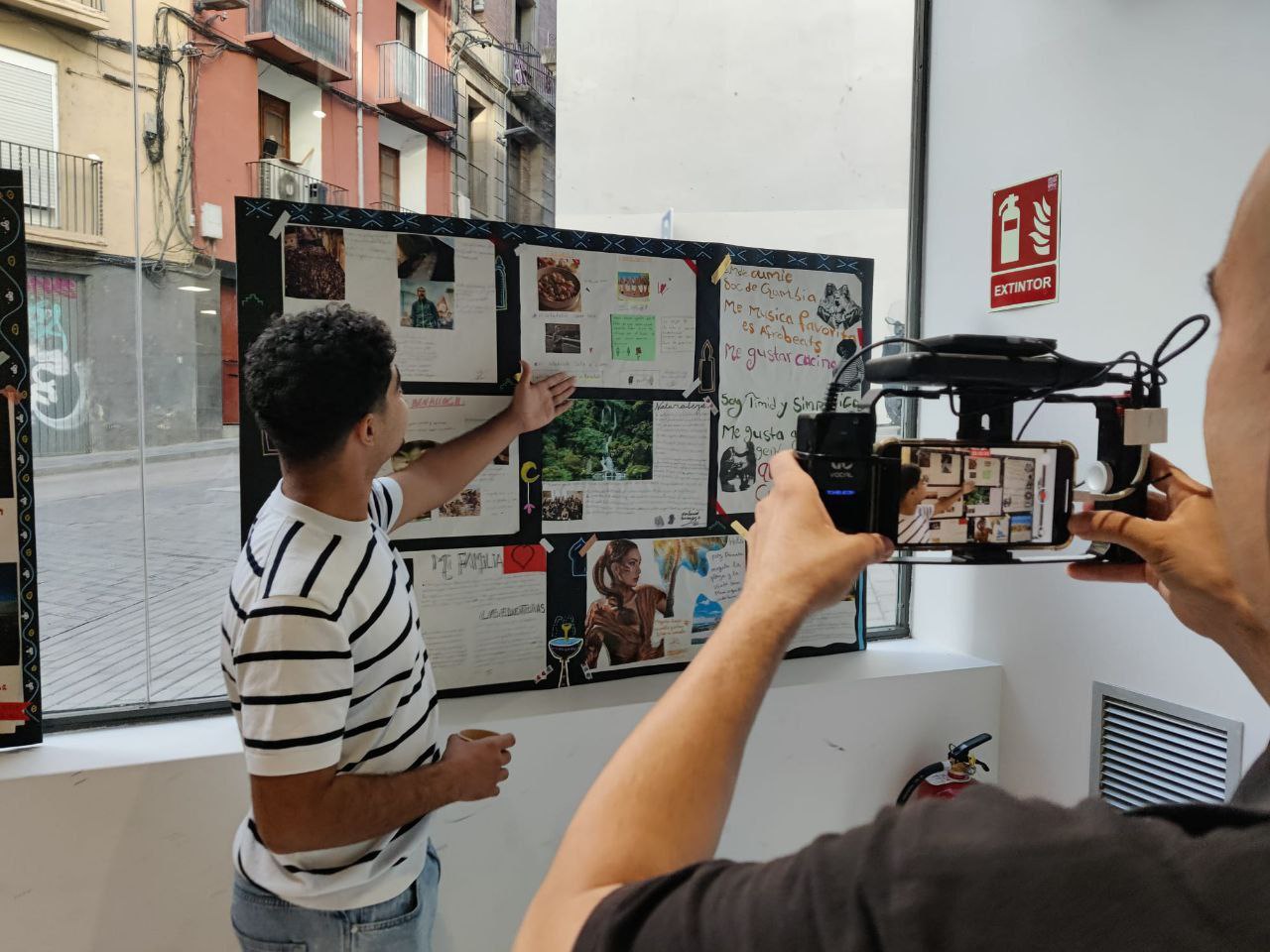 jove senyalant la seva obra , un mural sobre els seus interessos