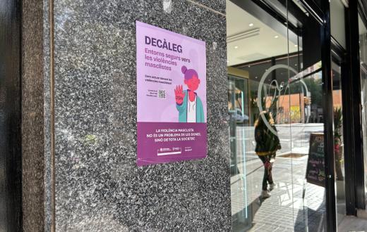 Un cartell de la campanya per difondre el "Decàleg: entorns segurs contra la violència masclista" llueix a l'entrada d'un establiment comercial