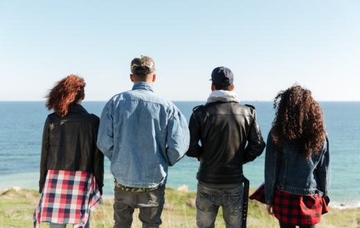 Joves d'esquena mirant al mar