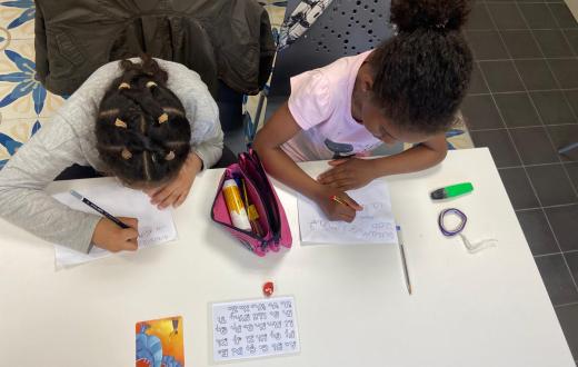 dues nenes fent deures a un servei de reforç escolar