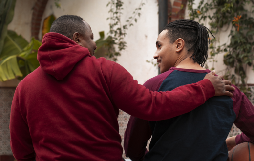 Un home agafa per l'esquena per donar suport un jove, que agafa una pilota de bàsquet