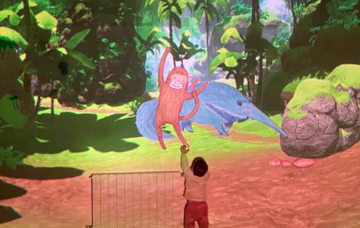 Nen en una sala immersiva interactuant