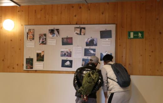 Dos homes atesos al CPA miren l'exposició de fotografies
