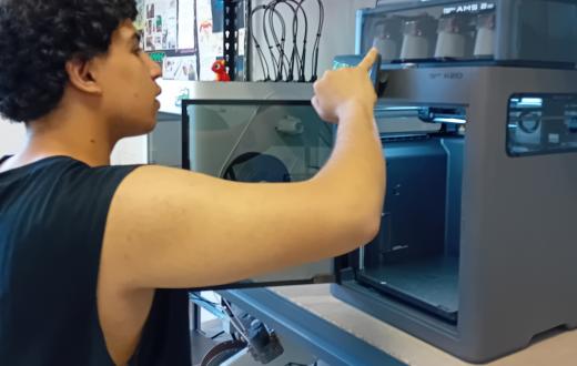Un jove posa en funcionament una impressora 3D