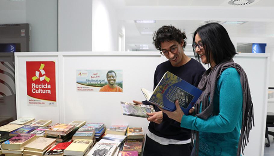 Un home i una dona consultant els llibres exposats