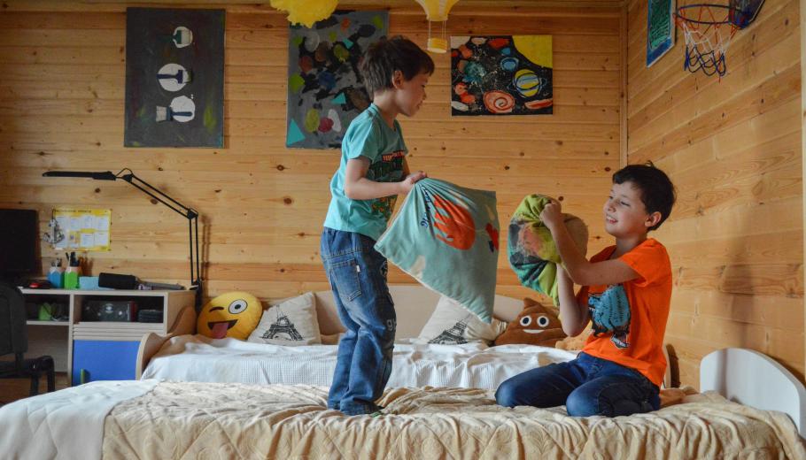 niños jugando sobre la cama