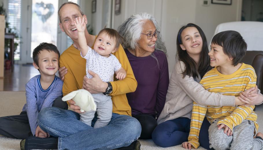 dos adults en actitud d'estima amb quatre infants que somriuren