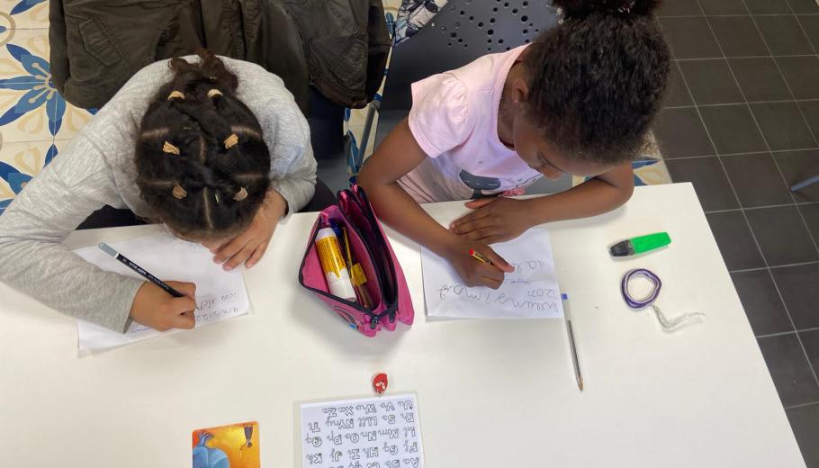 dues nenes fent deures a un servei de reforç escolar