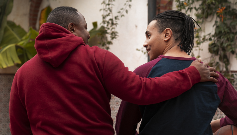 Un home agafa per l'esquena per donar suport un jove, que agafa una pilota de bàsquet