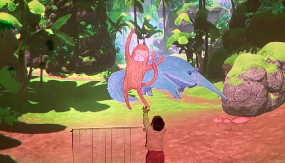 Niño en una sala immersiva interactuando