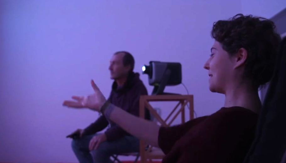una noia senyalant a la mà i explicant la seva experiència al seu terapeuta en una sala de realitat immersiva