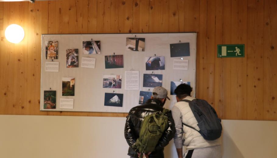 Dos homes atesos al CPA miren l'exposició de fotografies