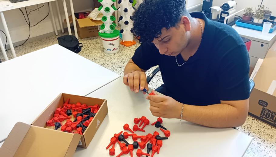 Un jove que atenem a Lleida manipula un dels connectors per a sistemes de distribució d’oxigen creat amb impressores 3D