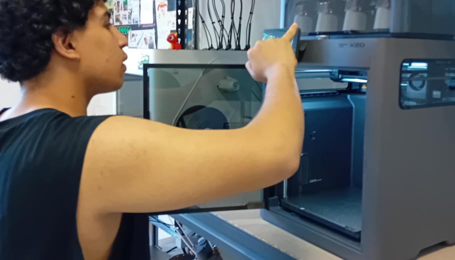 Un jove posa en funcionament una impressora 3D