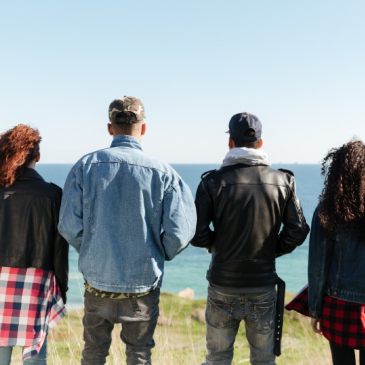 Joves d'esquena mirant al mar