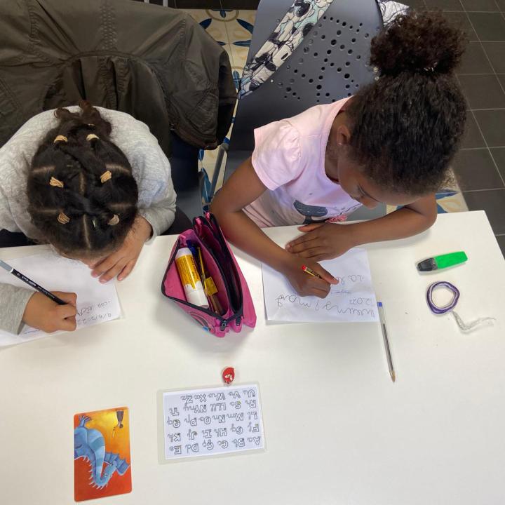 dues nenes fent deures a un servei de reforç escolar