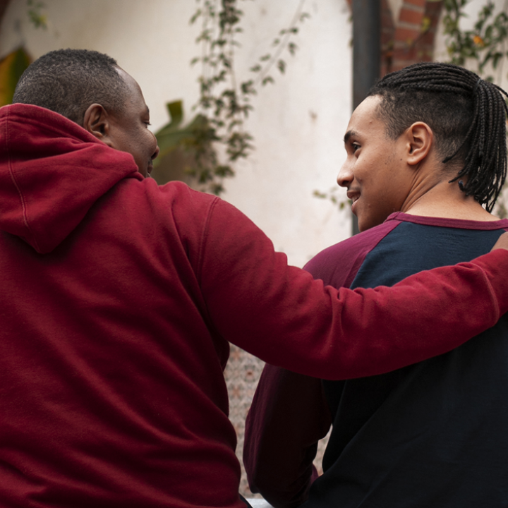 Un home agafa per l'esquena per donar suport un jove, que agafa una pilota de bàsquet