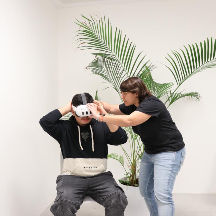 La responsable de realitat virtual, Natalia Alonso, posa les ulleres a un jove per treballar una experiència de realitat virtual