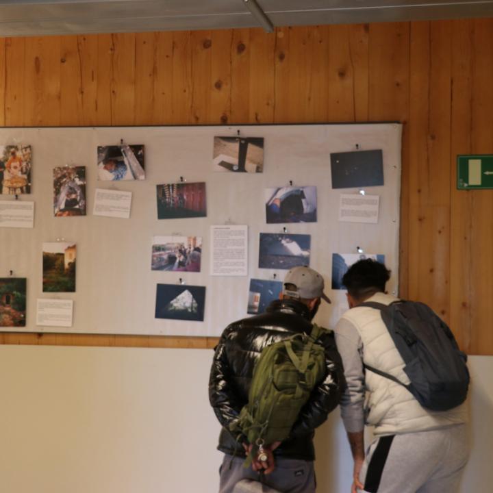 Dos homes atesos al CPA miren l'exposició de fotografies