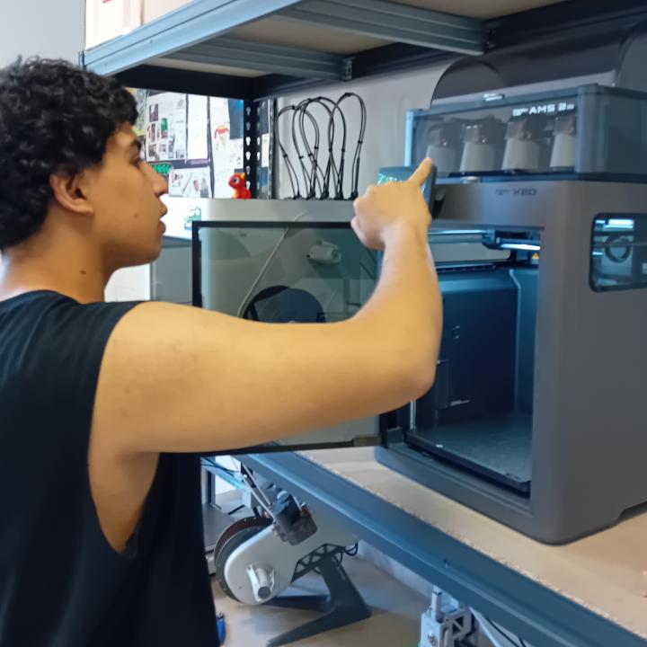 Un jove posa en funcionament una impressora 3D