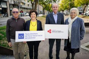 Dues parelles de gent gran mostrant els cartells amb els logos de la Taula i el Fòrum de Síndics i Síndiques