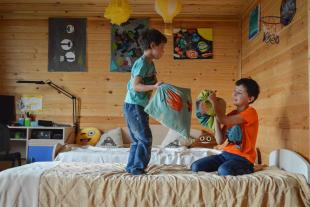 niños jugando sobre la cama