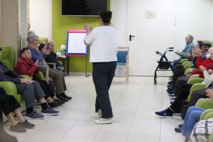 Una dona fa una activitat de dinamització en una residència per a persones grans de Suara Cooperativa