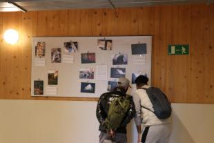Dos homes atesos al CPA miren l'exposició de fotografies
