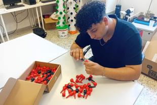 Un jove que atenem a Lleida manipula un dels connectors per a sistemes de distribució d’oxigen creat amb impressores 3D